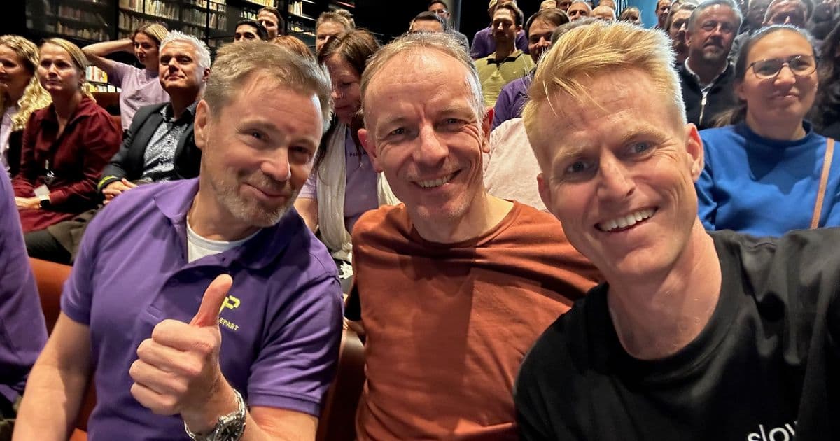 Mads Nissen wearing a Slowly shirt at the Puzzlepart 15-year anniversary celebration with former colleagues in an auditorium, 2023